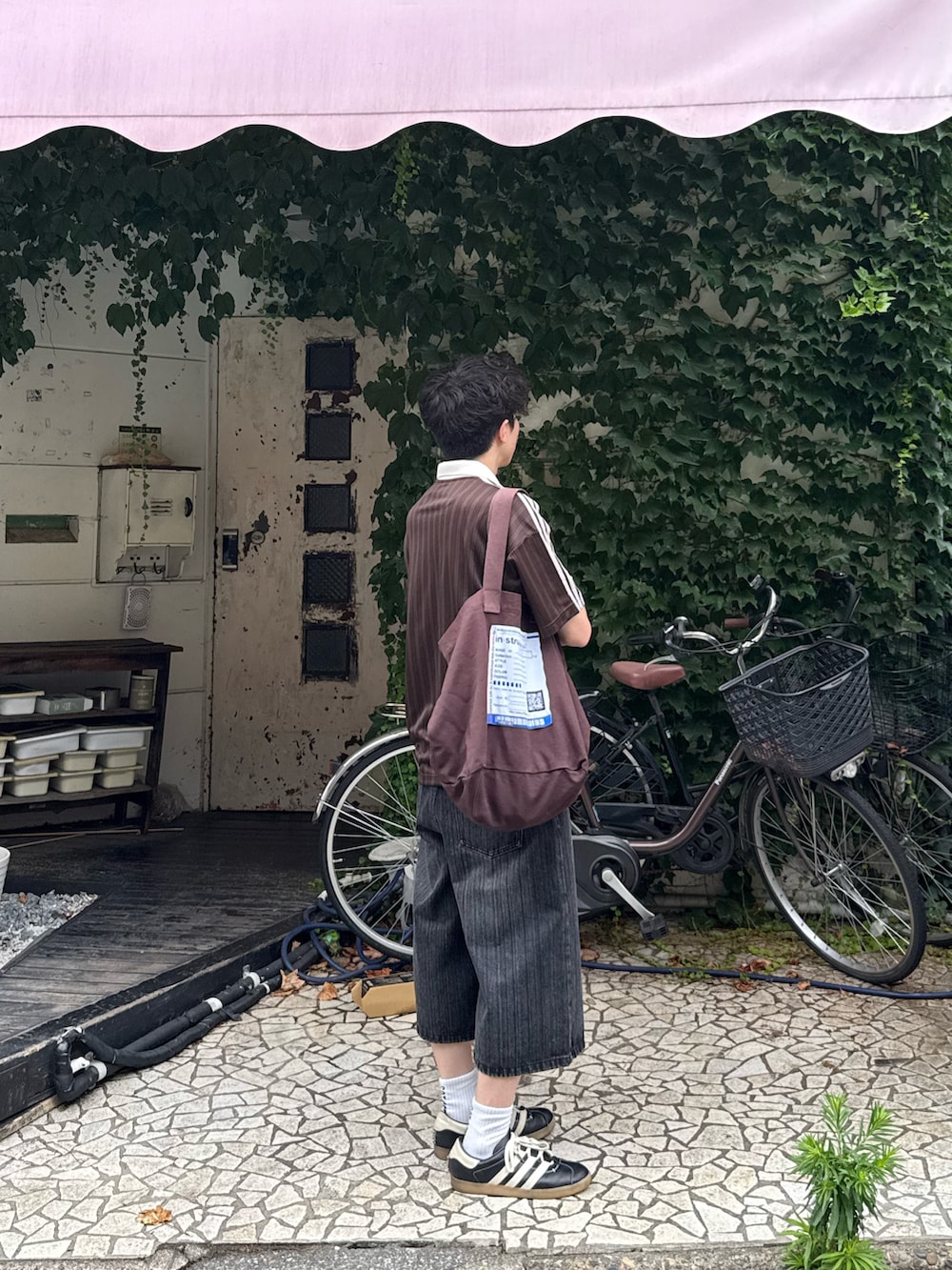 ブラウン系のTシャツ/カットソー、グレー系のデニムパンツ、ブラウン系のトートバッグを着用したメンズの夏コーディネートの3枚目の写真