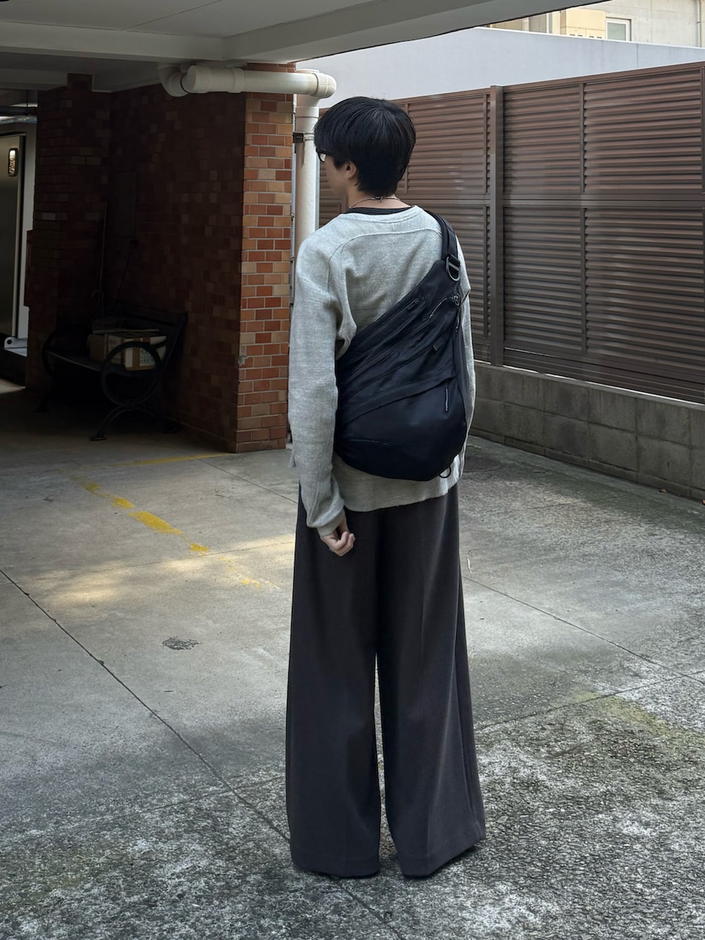 グレー系のTシャツ/カットソー、ブラウン系のスラックス、ブラック系のモカシン/デッキシューズを着用したメンズの秋コーディネートの3枚目の写真