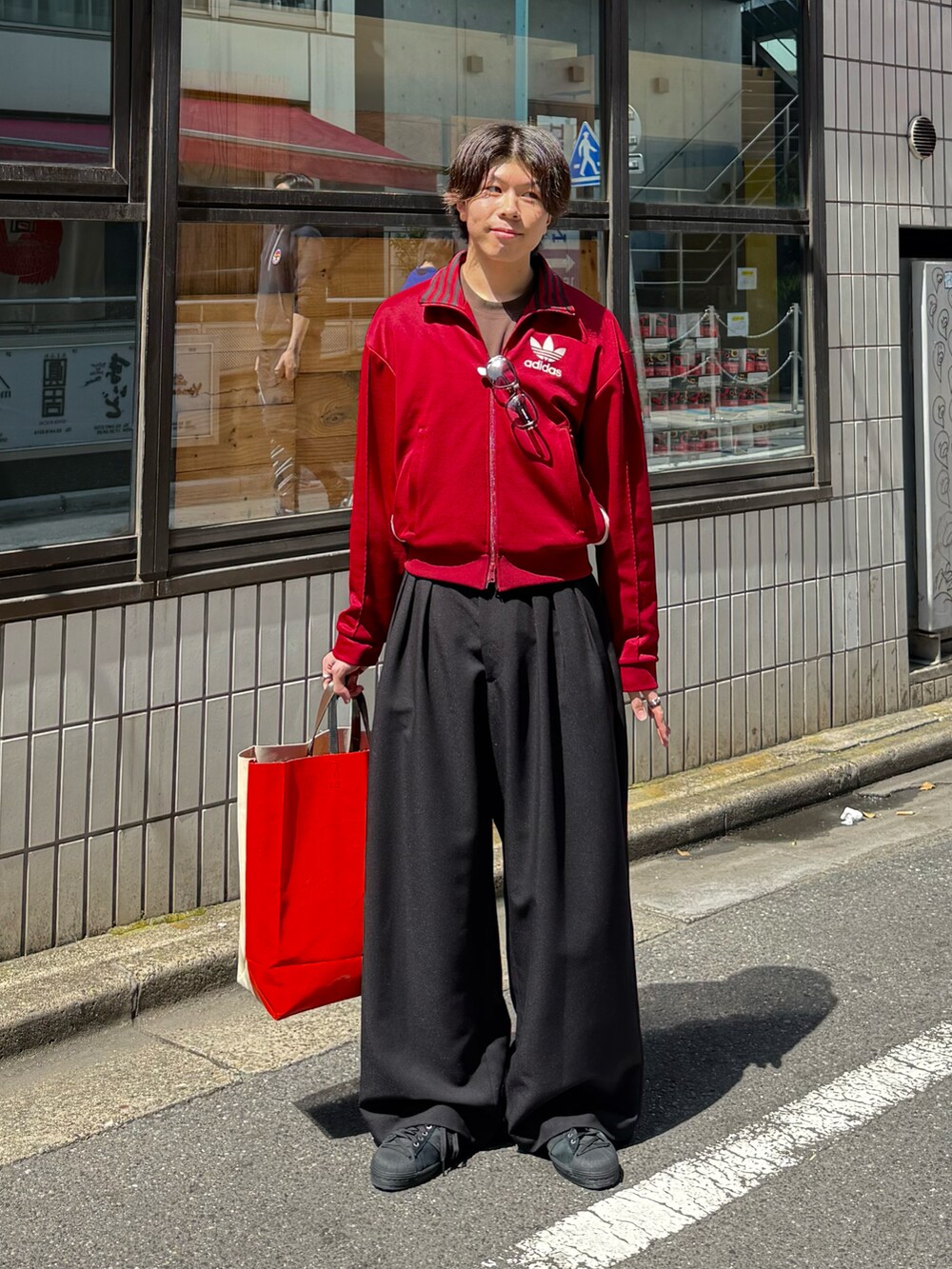 レッド系のその他トップス、ブラウン系のTシャツ/カットソー、ブラック系のスラックスを着用したメンズの春コーディネートの2枚目の写真