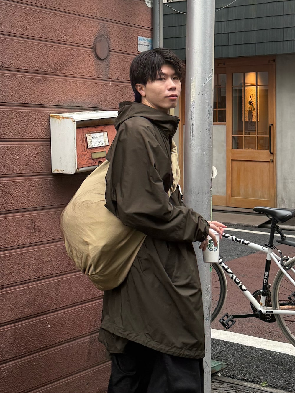 ブラック系のモカシン/デッキシューズ、ブラック系のその他パンツ、ベージュ系のショルダーバッグを着用したメンズの春コーディネートの3枚目の写真