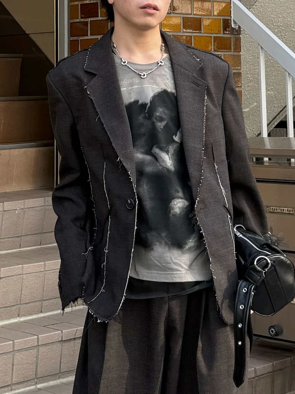 ブラック系のブーツ、ホワイト系のTシャツ/カットソー、ブラック系のショルダーバッグを着用したメンズの春コーディネートの3枚目の写真