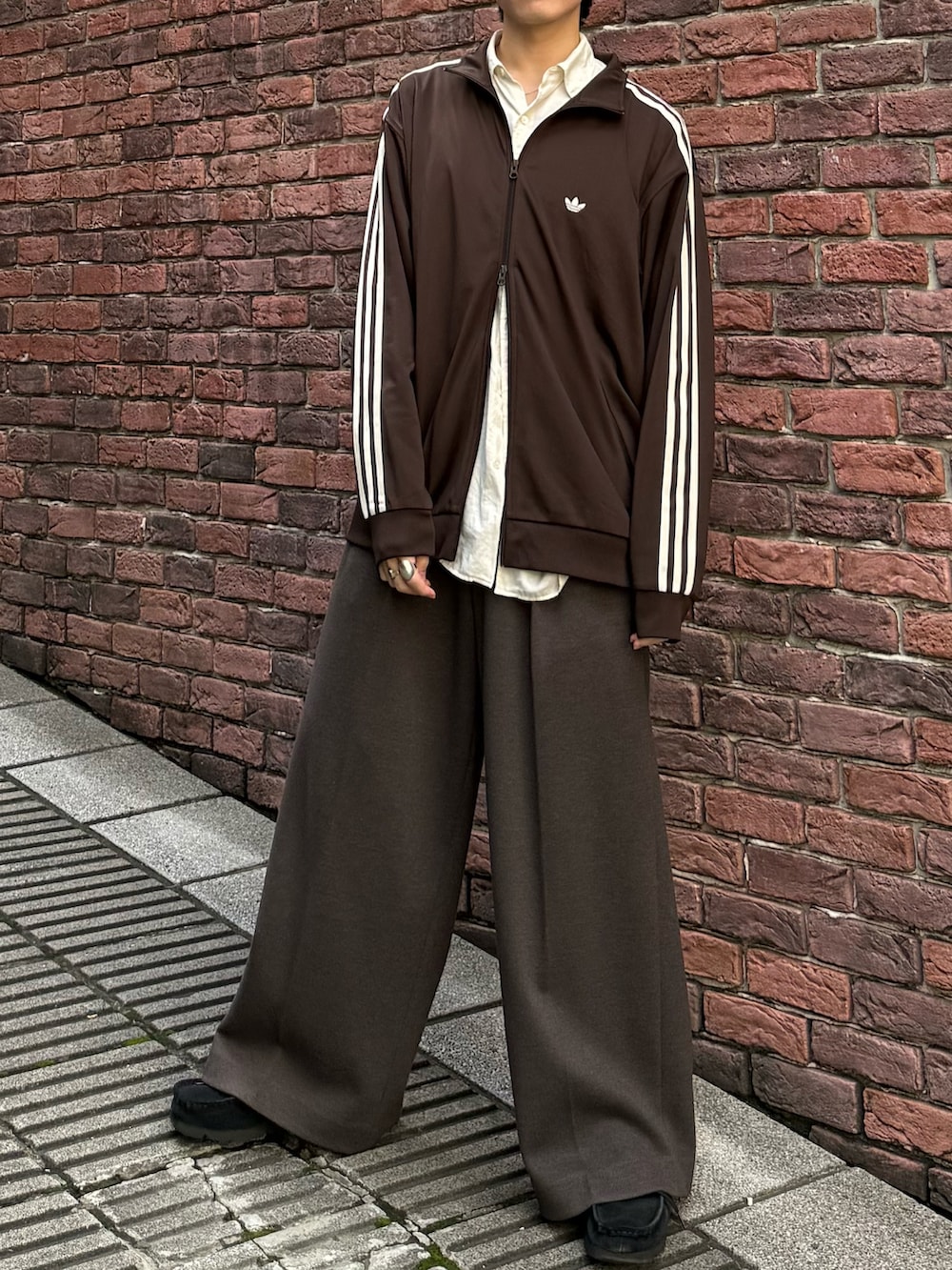 ブラウン系のジャージ、ブラウン系のスラックス、ブラック系のモカシン/デッキシューズを着用したメンズの秋コーディネートの4枚目の写真