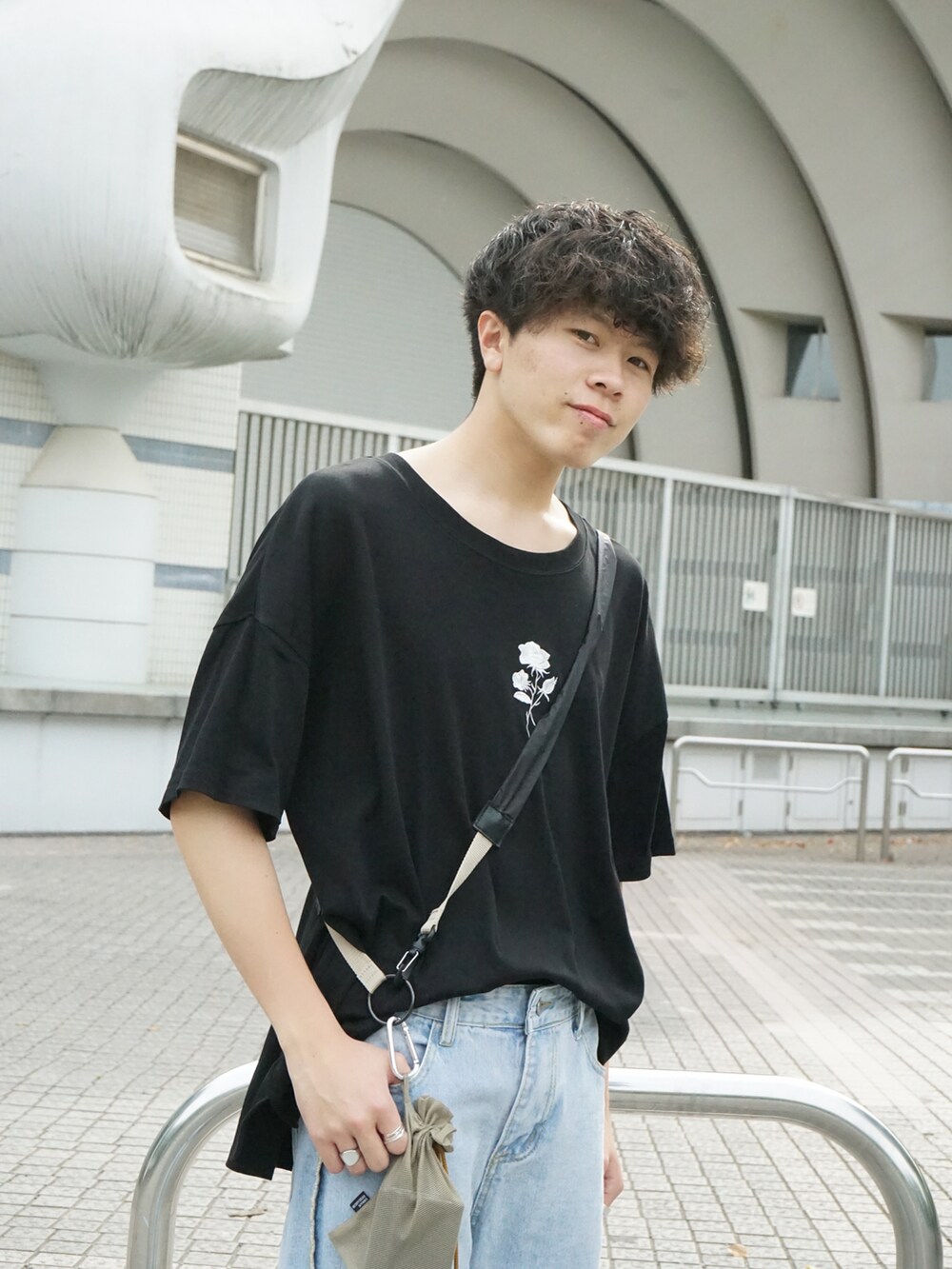 ブラック系のTシャツ/カットソー、ベージュ系のショルダーバッグ、ブルー系のデニムパンツを着用したメンズの春コーディネートの4枚目の写真