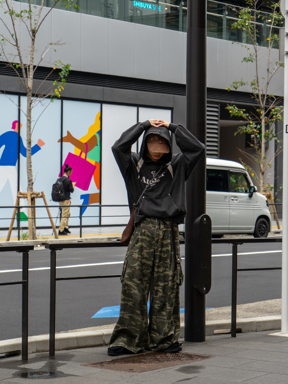 ブラック系のパーカー、その他のカーゴパンツ、ブラウン系のショルダーバッグを着用したメンズの秋コーディネートの3枚目の写真