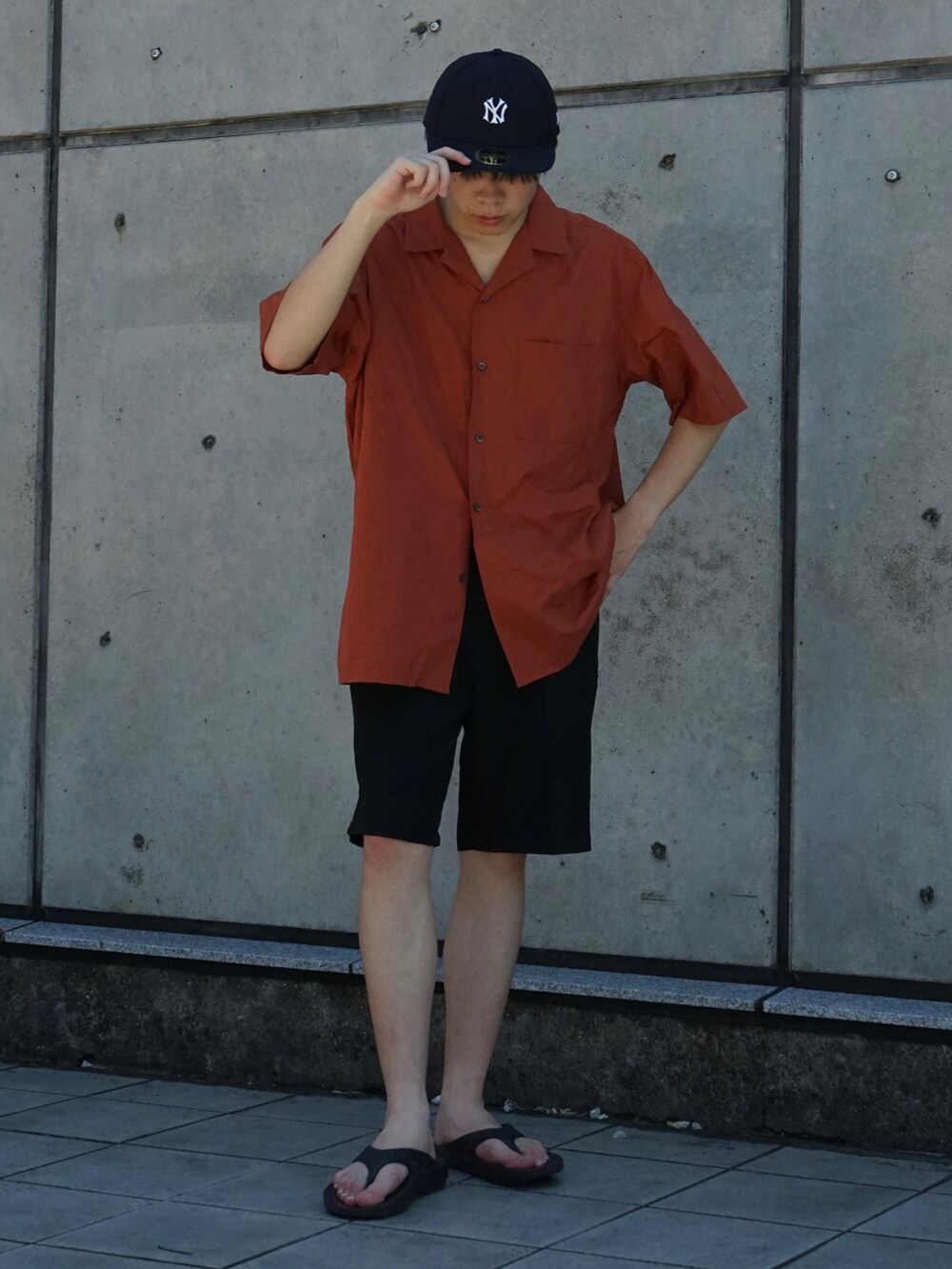 オレンジ系のシャツ/ブラウス、ブラック系のスラックス、ブラック系のサンダルを着用したメンズの夏コーディネートの3枚目の写真