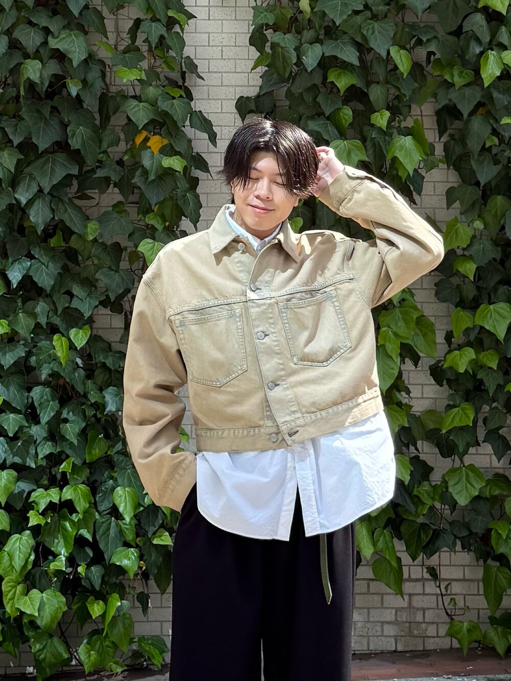 ベージュ系のデニムジャケット、ホワイト系のシャツ/ブラウス、ブラック系のスラックスを着用したメンズの春コーディネートの2枚目の写真