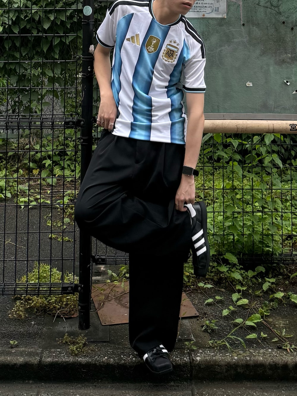 ホワイト系のTシャツ/カットソー、ブラック系のスラックス、ブラック系のスニーカーを着用したメンズの夏コーディネートの3枚目の写真