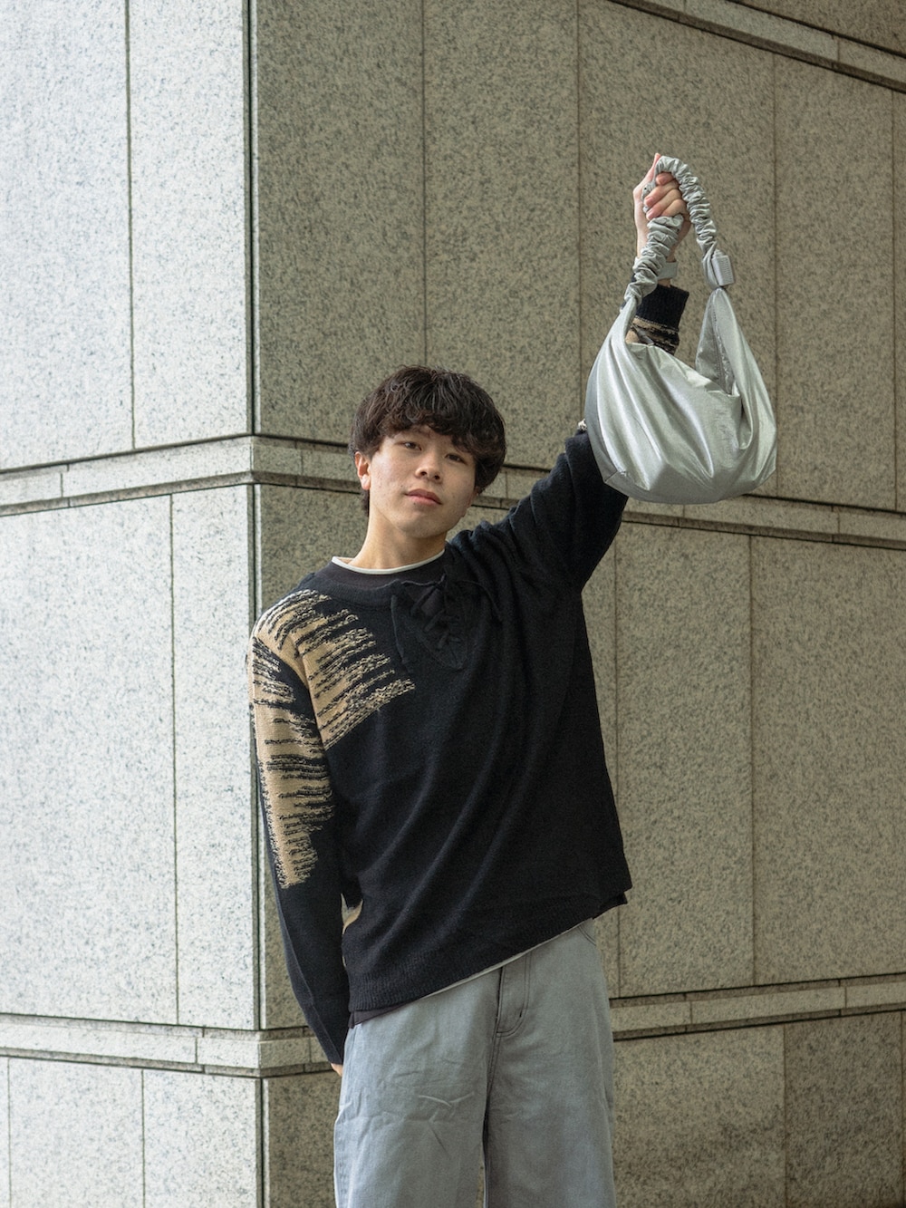 ブラック系のニット/セーター、ブラック系のデニムパンツ、ブラック系のブーツを着用したメンズの春コーディネートの3枚目の写真