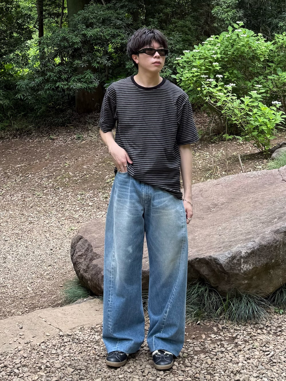 ブラック系のTシャツ/カットソー、ブルー系のデニムパンツ、ブラック系のスニーカーを着用したメンズの春コーディネートの2枚目の写真
