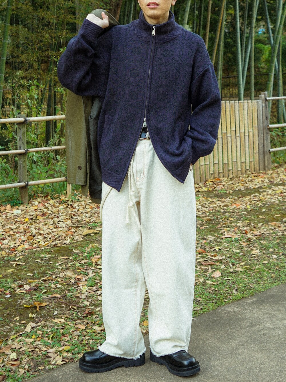 パープル系のニット/セーター、ブラック系のデニムパンツ、ブラック系のカバーオールを着用したメンズの冬コーディネートの5枚目の写真