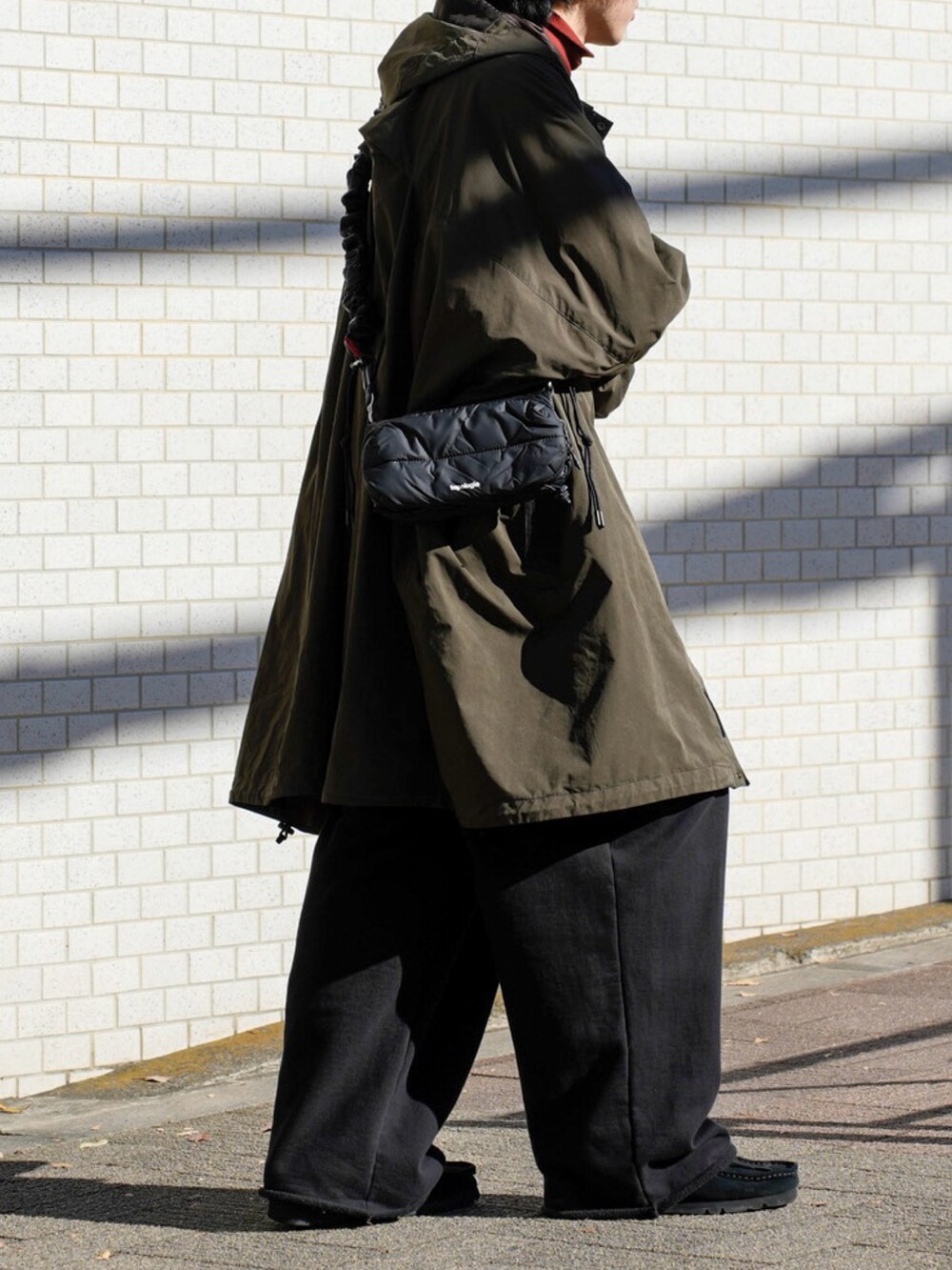 ブラック系のスウェット、ブラック系のショルダーバッグ、ブラック系のスウェットパンツを着用したメンズの冬コーディネートの5枚目の写真