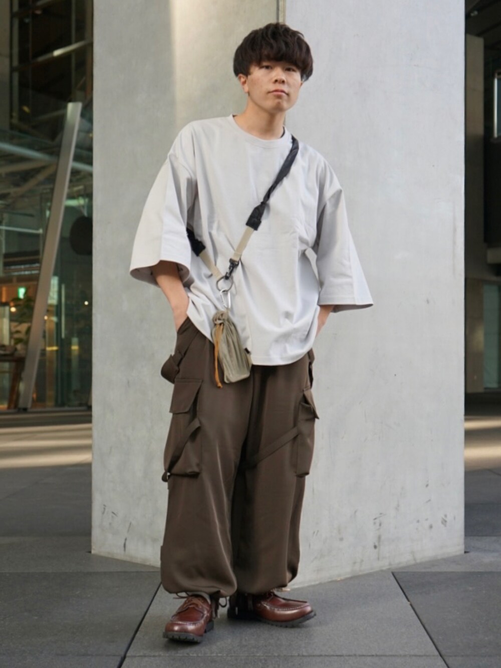 グレー系のTシャツ/カットソー、グリーン系のサロペット/オーバーオール、ベージュ系のショルダーバッグを着用したメンズの冬コーディネートの3枚目の写真