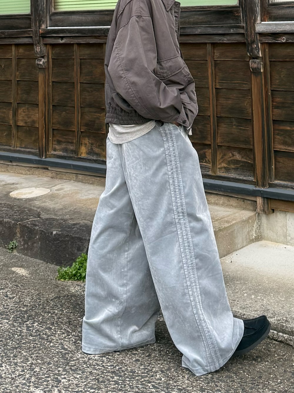 グレー系のスウェットパンツ、ブラック系のモカシン/デッキシューズ、グレー系のTシャツ/カットソーを着用したメンズの秋コーディネートの2枚目の写真