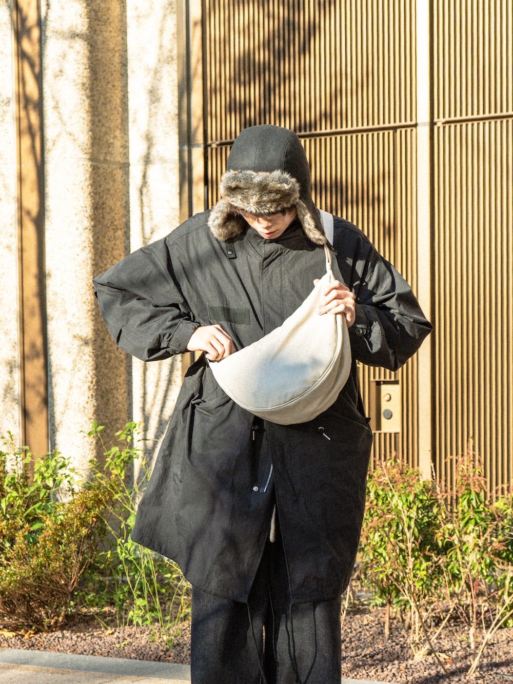 ブラック系のモッズコート、ブラック系のデニムパンツ、ブラック系のブーツを着用したメンズの冬コーディネートの4枚目の写真