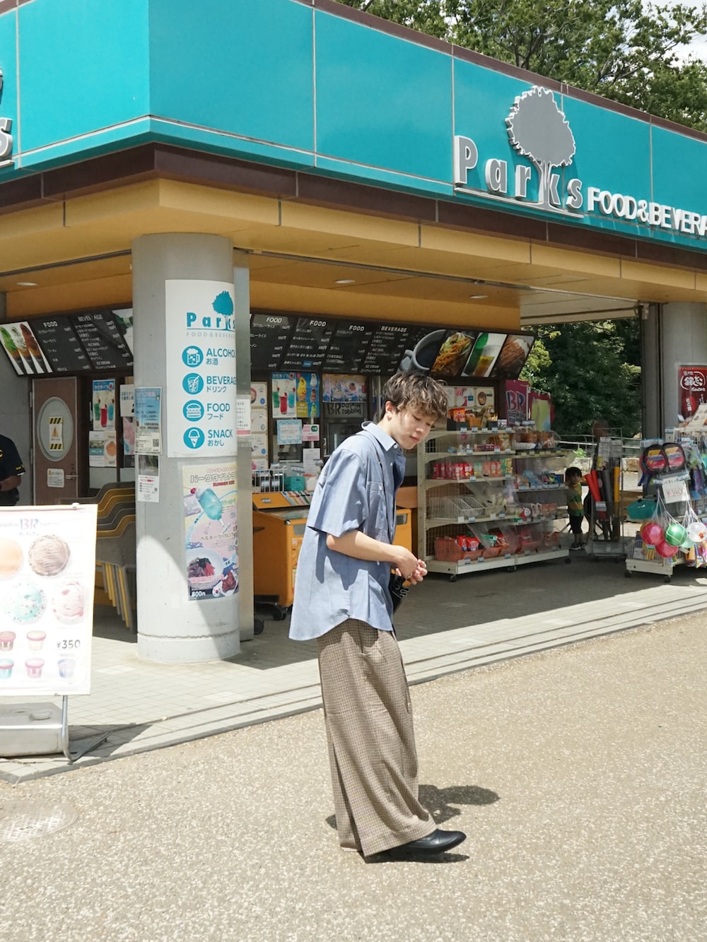 ブルー系のシャツ/ブラウス、ベージュ系のスラックス、ブラック系のショルダーバッグを着用したメンズの夏コーディネートの3枚目の写真
