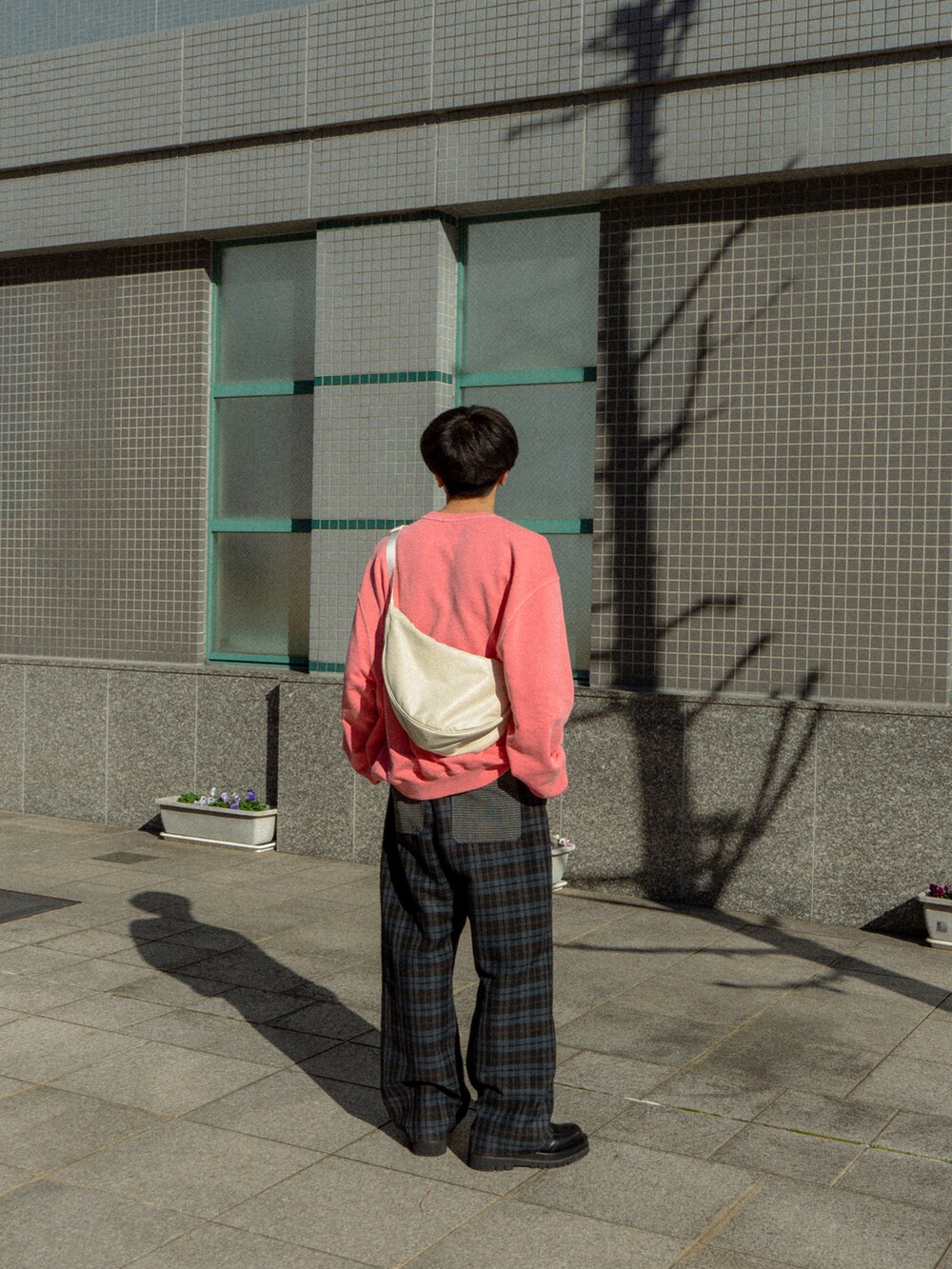 ピンク系のスウェット、ブラック系のその他パンツ、ブラック系のドレスシューズを着用したメンズの冬コーディネートの3枚目の写真