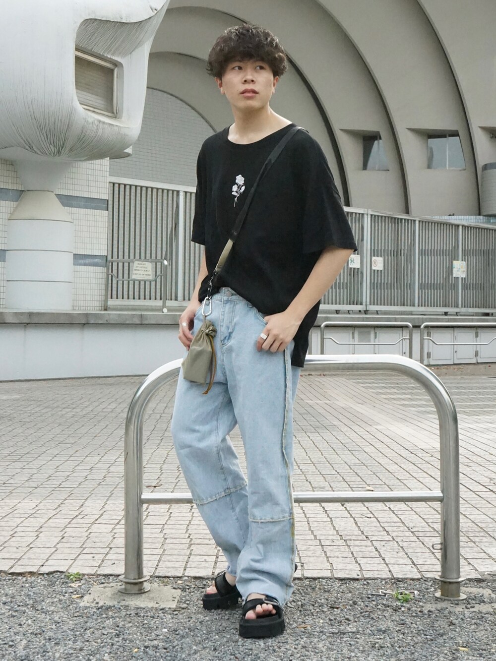 ブラック系のTシャツ/カットソー、ベージュ系のショルダーバッグ、ブルー系のデニムパンツを着用したメンズの春コーディネートの3枚目の写真