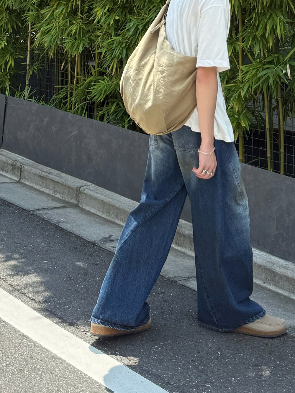 ベージュ系のその他シューズ、ブルー系のデニムパンツ、ベージュ系のショルダーバッグを着用したメンズの夏コーディネートの4枚目の写真