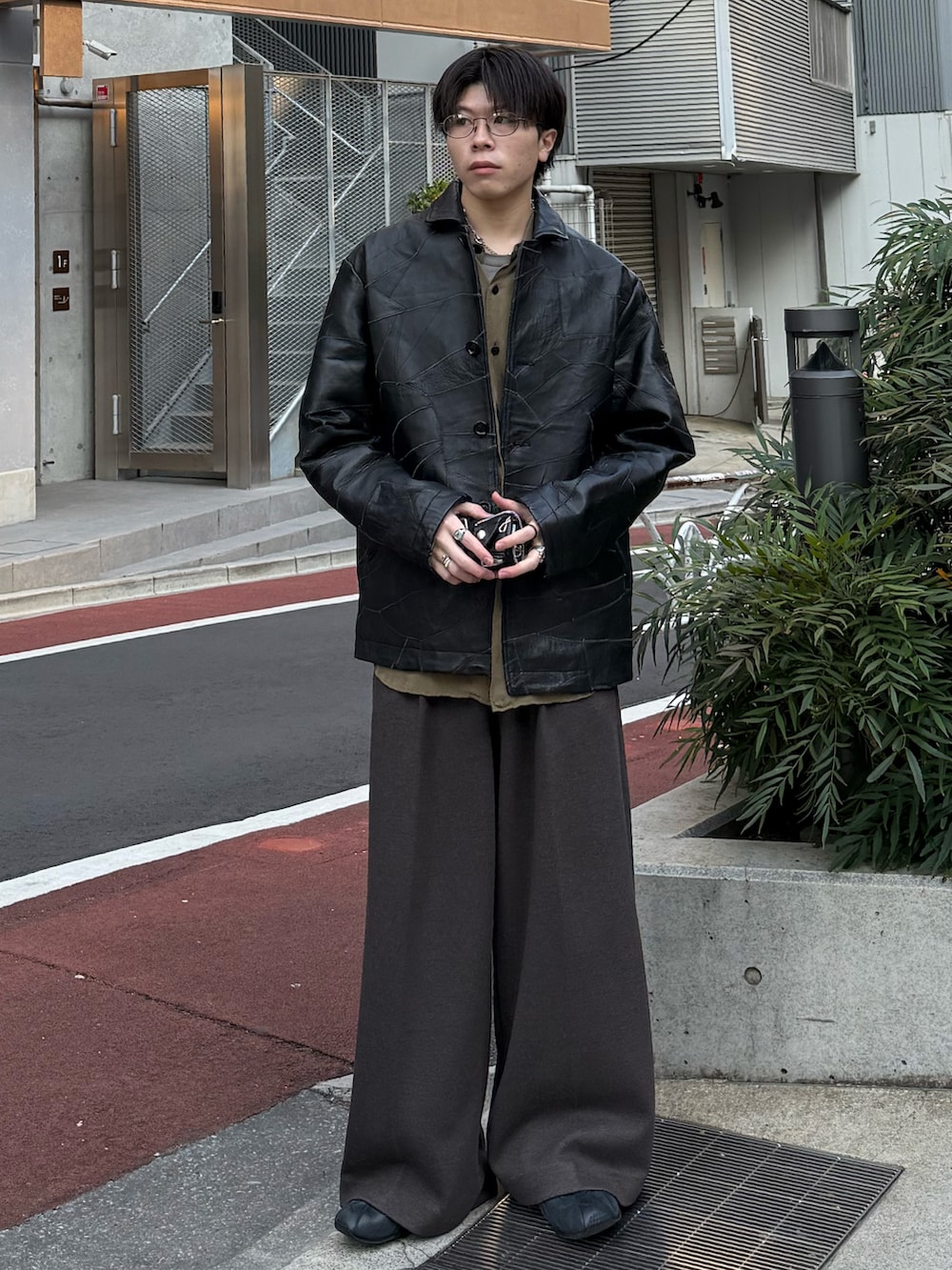 ブラック系のジャケット/アウター、グリーン系のシャツ/ブラウス、ブラウン系のスラックスを着用したメンズの冬コーディネートの2枚目の写真