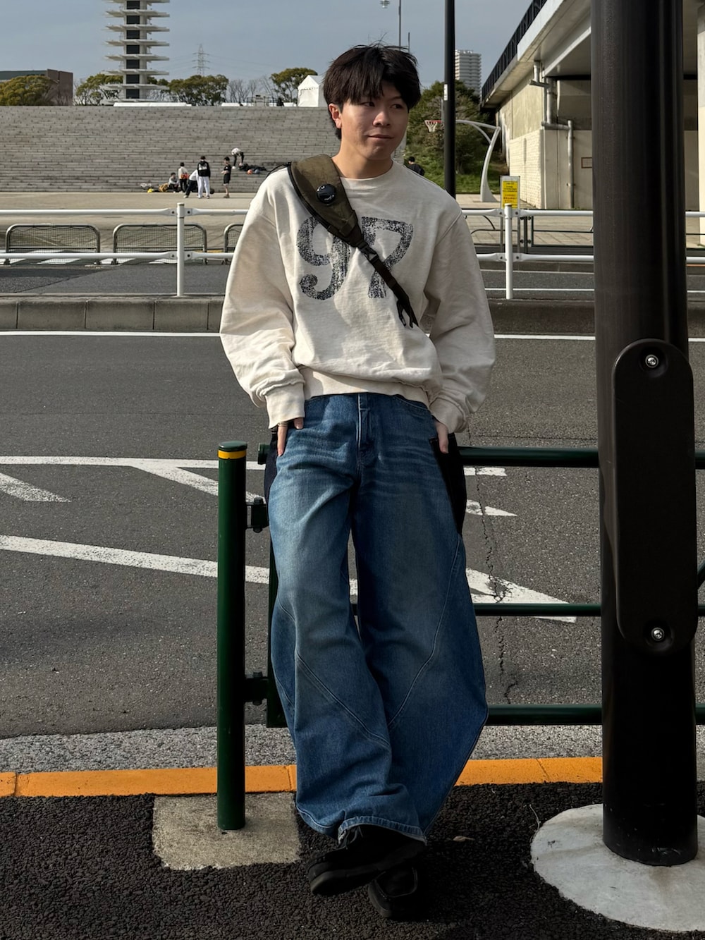 ホワイト系のスウェット、ブルー系のデニムパンツ、グリーン系のバックパック/リュックを着用したメンズの春コーディネートの2枚目の写真