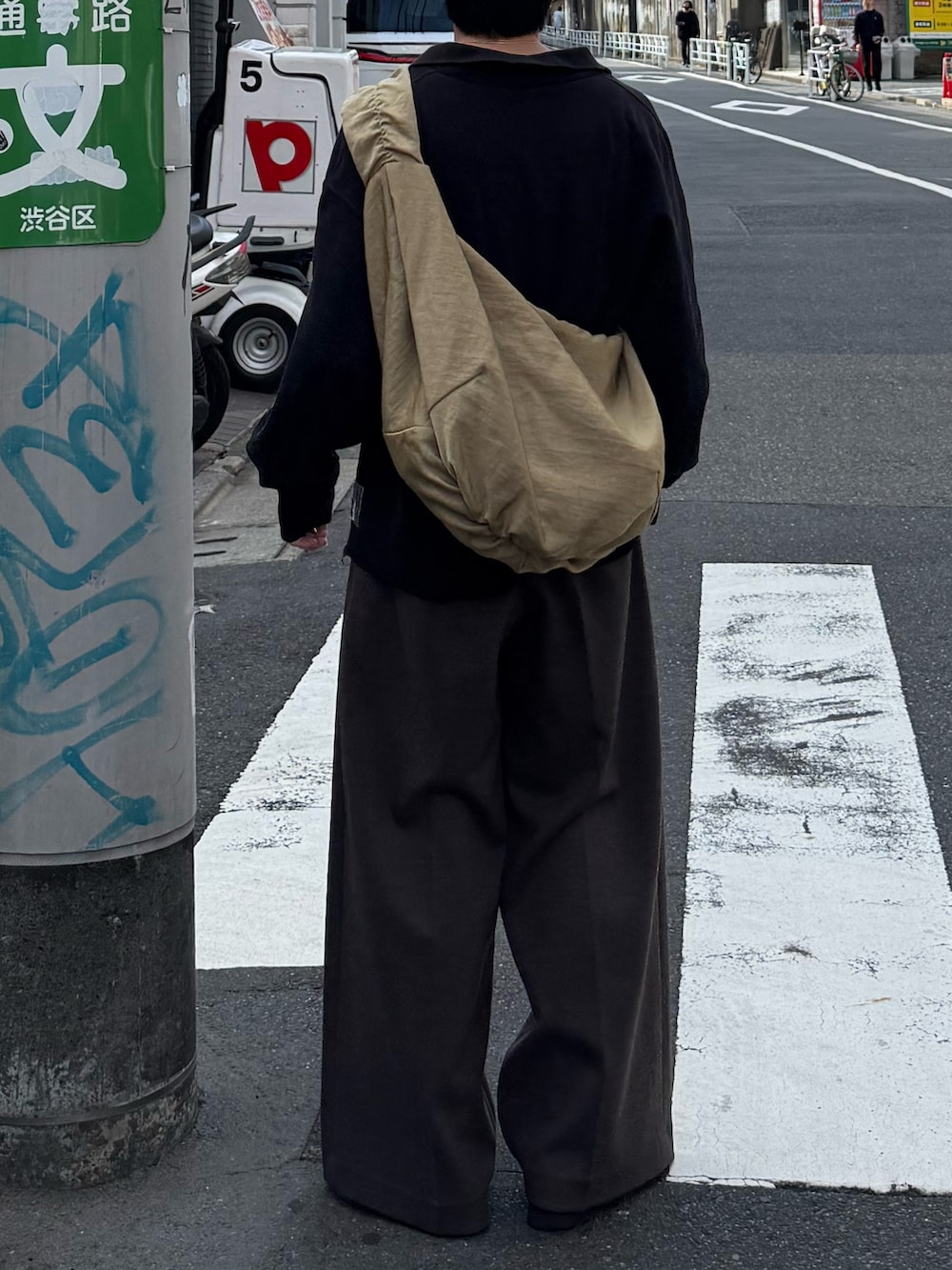 ブラック系のスウェット、ブラウン系のスラックス、ベージュ系のショルダーバッグを着用したメンズの秋コーディネートの3枚目の写真