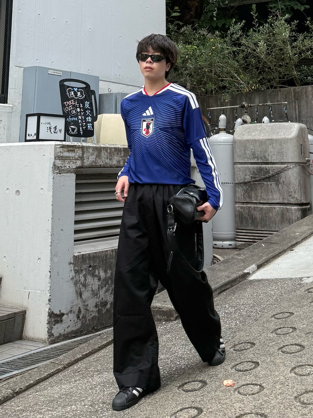ブルー系のTシャツ/カットソー、ブラック系のその他パンツ、ブラック系のショルダーバッグを着用したメンズの夏コーディネートの2枚目の写真