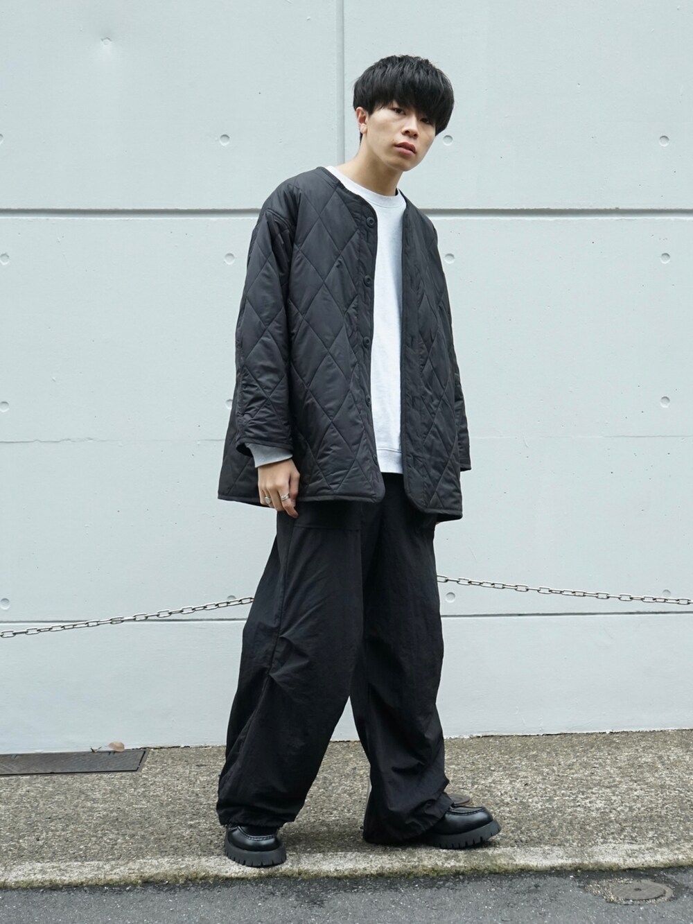 グレー系のスウェット、ブラック系のその他パンツ、ブラック系のローファーを着用したメンズの秋コーディネートの2枚目の写真