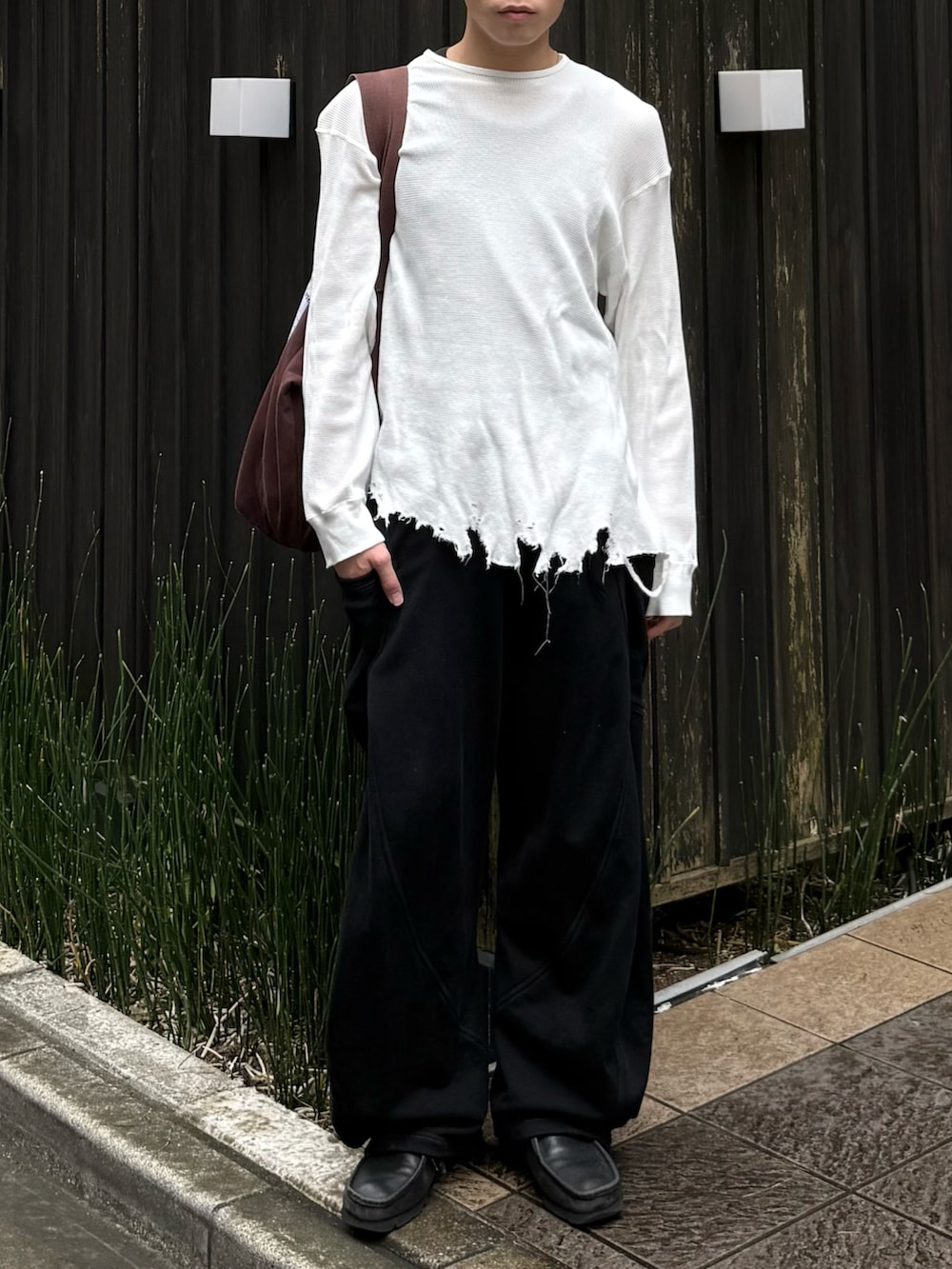 ホワイト系のTシャツ/カットソー、ブラック系のスウェットパンツ、ブラウン系のトートバッグを着用したメンズの秋コーディネートの3枚目の写真