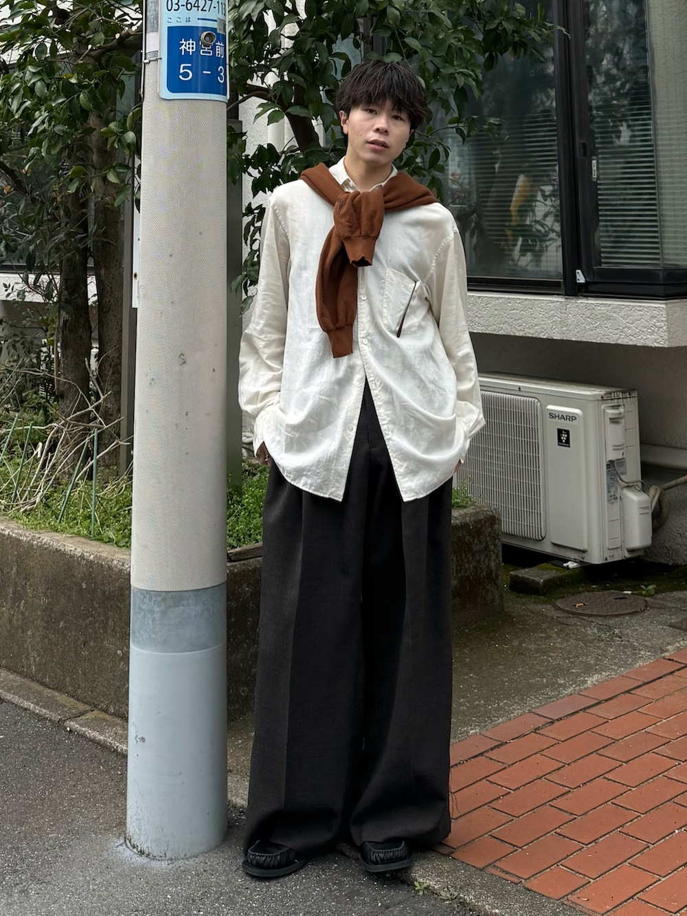 ブラウン系のカーディガン/ボレロ、ブラウン系のスラックス、ブラック系のローファーを着用したメンズの春コーディネートの2枚目の写真