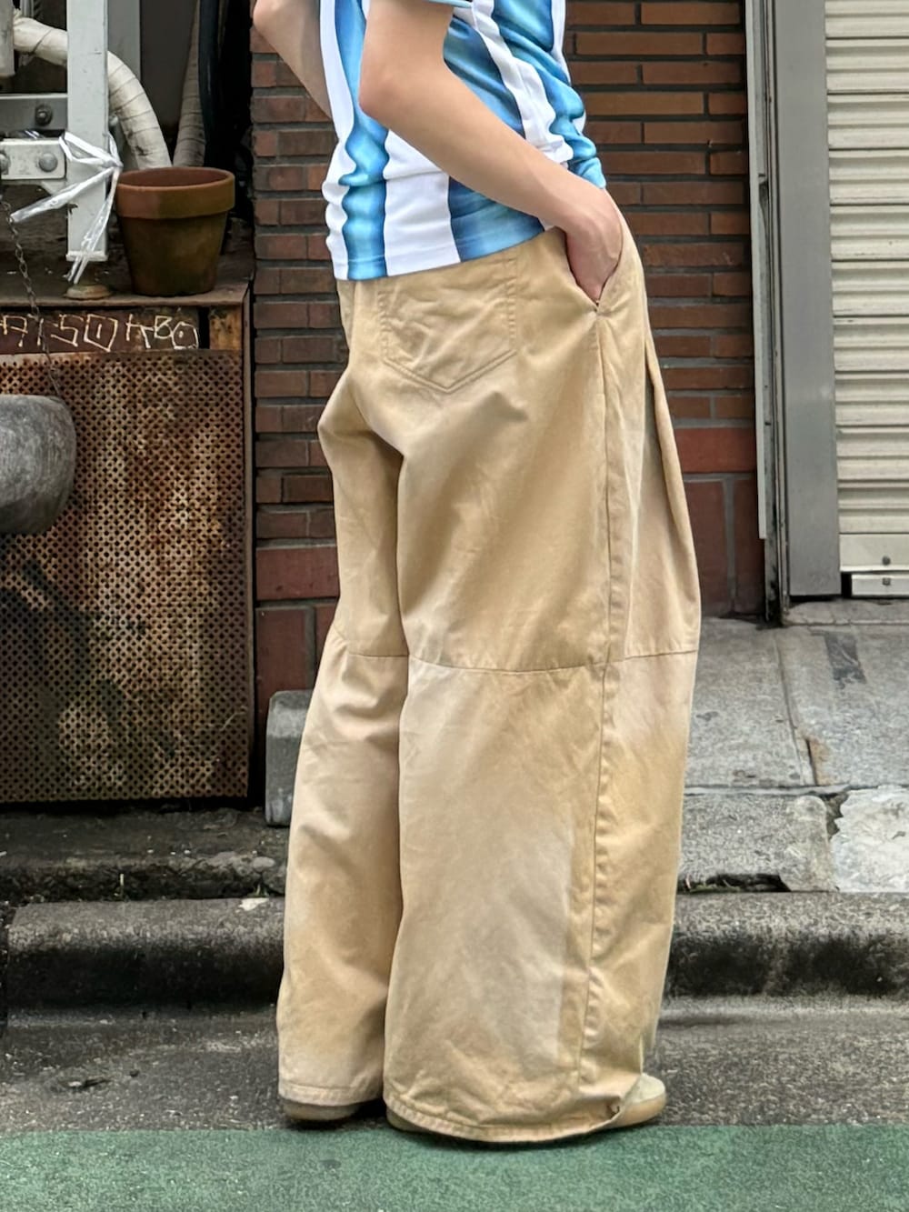ホワイト系のTシャツ/カットソー、ベージュ系のチノパンツ、ホワイト系のスニーカーを着用したメンズの夏コーディネートの2枚目の写真