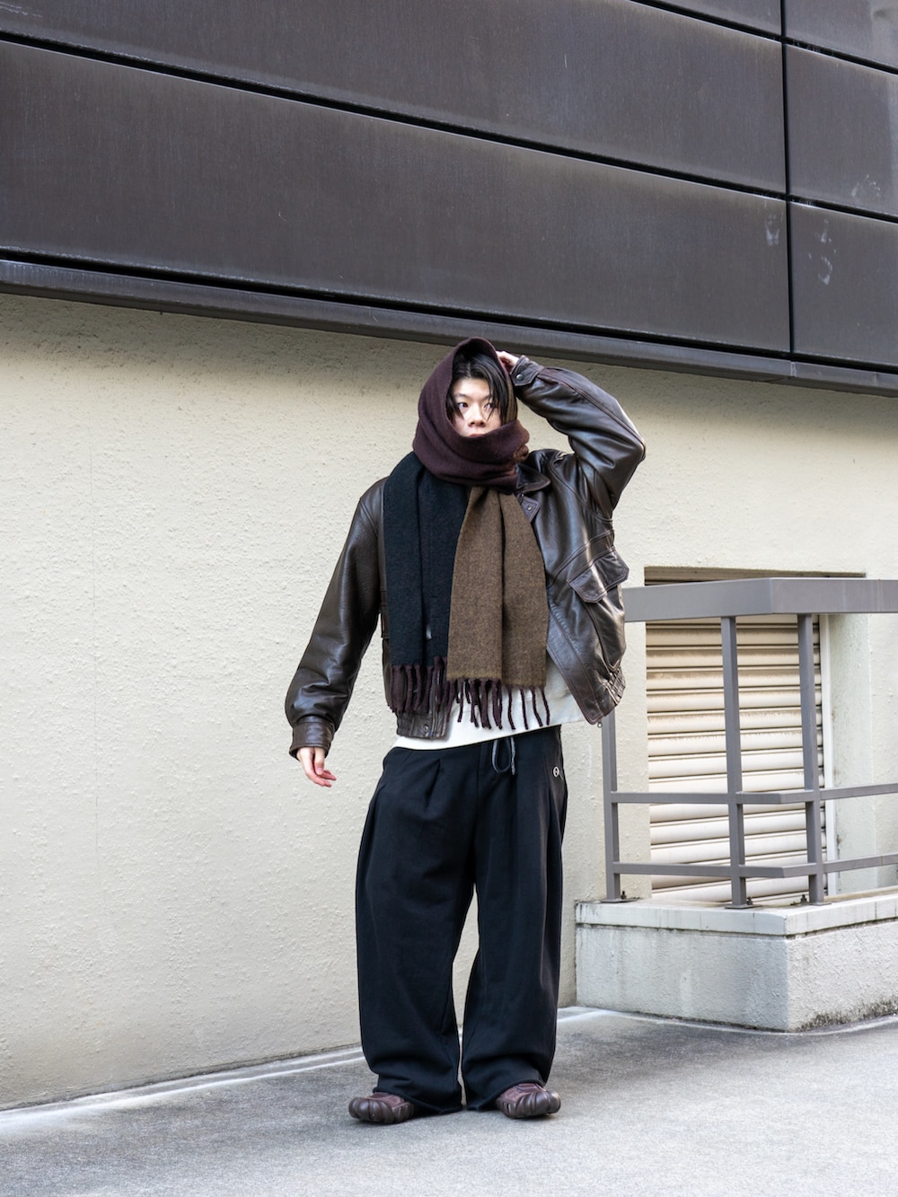 ブラウン系のブルゾン、ブラック系のスウェットパンツ、ブラウン系のスニーカーを着用したメンズの冬コーディネートの3枚目の写真