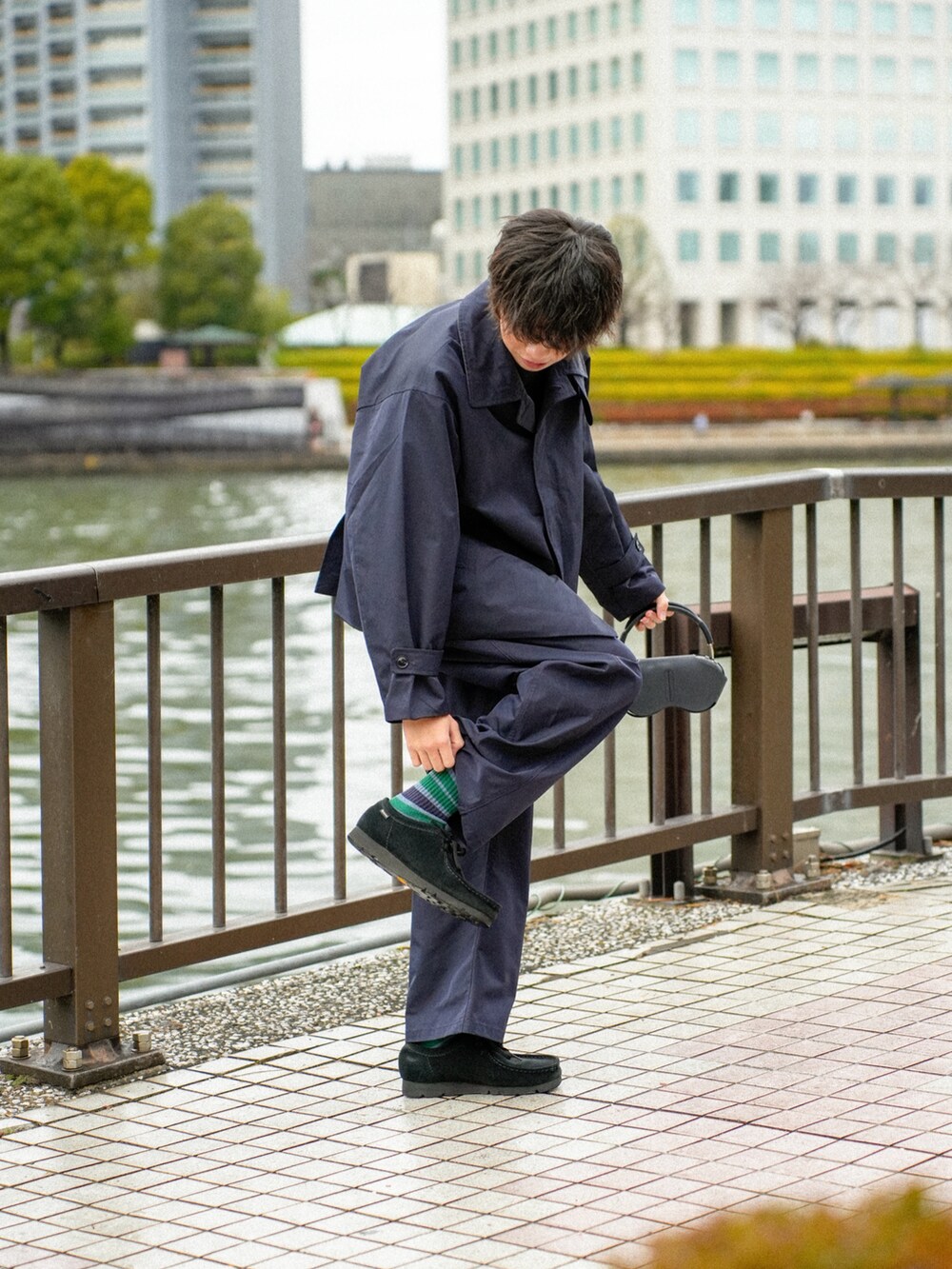 ブラック系のステンカラーコート、ブラック系のその他パンツ、ブラック系のその他シューズを着用したメンズの冬コーディネートの3枚目の写真