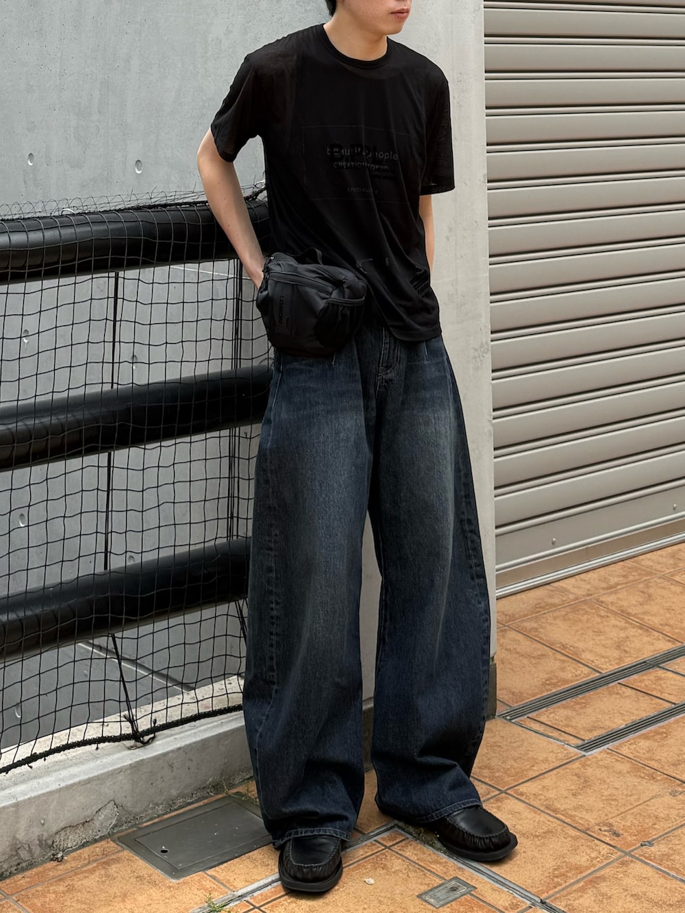 ブラック系のTシャツ/カットソー、ブルー系のデニムパンツ、ブラウン系のタンクトップを着用したメンズの夏コーディネートの4枚目の写真
