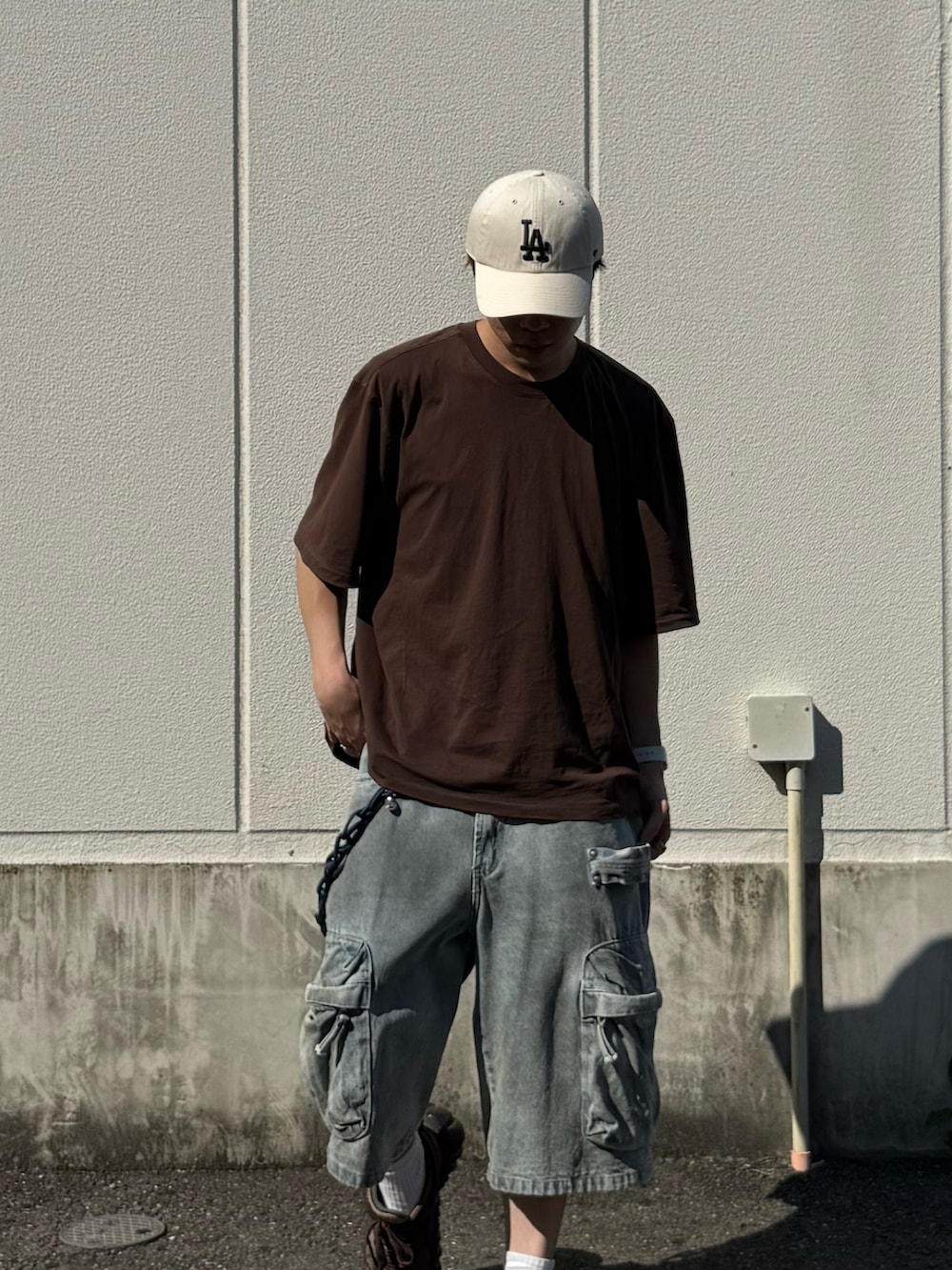 ブラウン系のTシャツ/カットソー、ブルー系のデニムパンツ、ブラウン系のスニーカーを着用したメンズの夏コーディネートの2枚目の写真