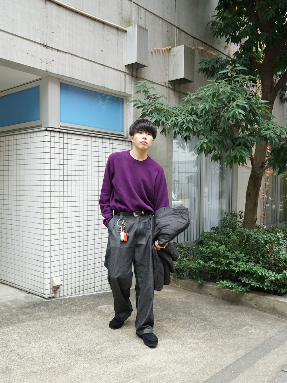 パープル系のニット/セーター、ブラック系のミリタリージャケット、グレー系のデニムパンツを着用したメンズの冬コーディネートの3枚目の写真