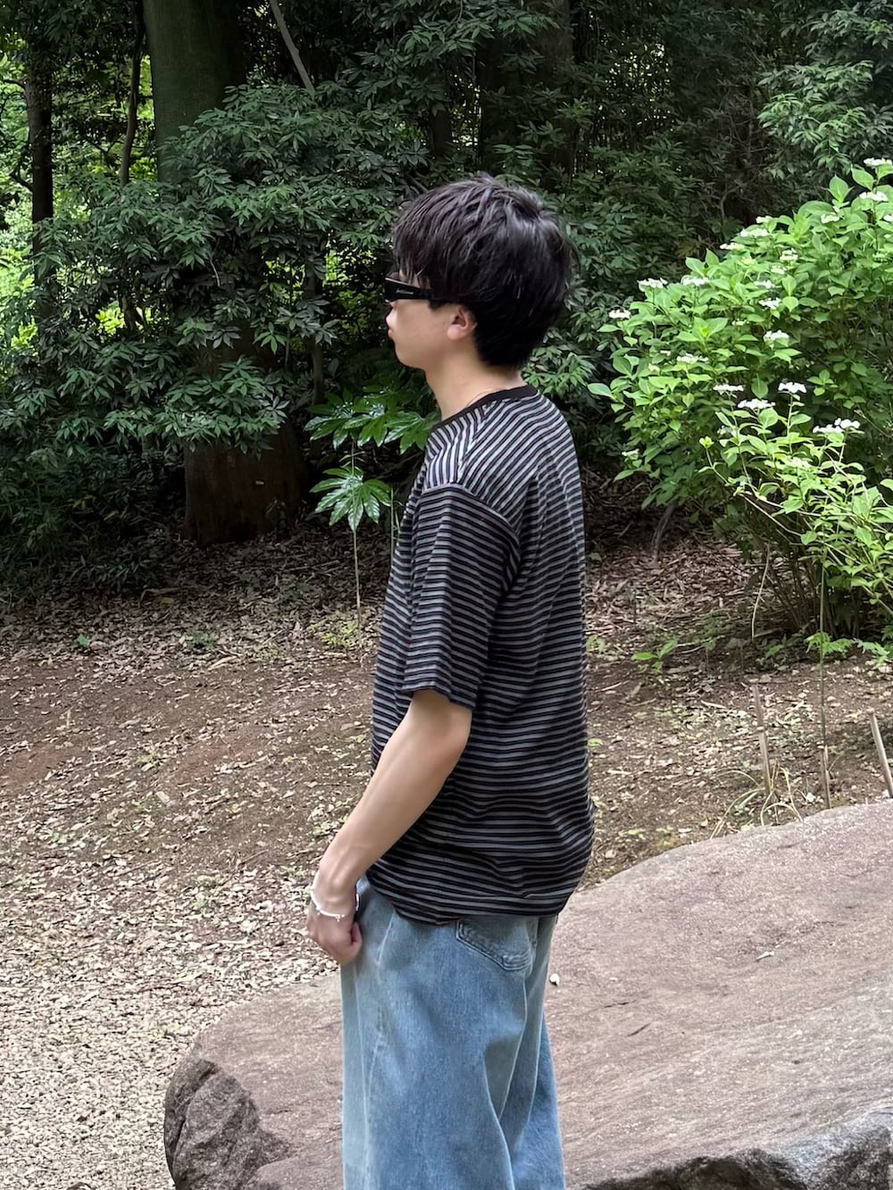 ブラック系のTシャツ/カットソー、ブルー系のデニムパンツ、ブラック系のスニーカーを着用したメンズの春コーディネートの4枚目の写真