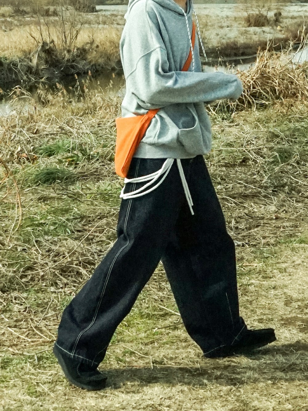 グレー系のパーカー、ブルー系のデニムパンツ、ブラック系のその他シューズを着用したメンズの冬コーディネートの4枚目の写真