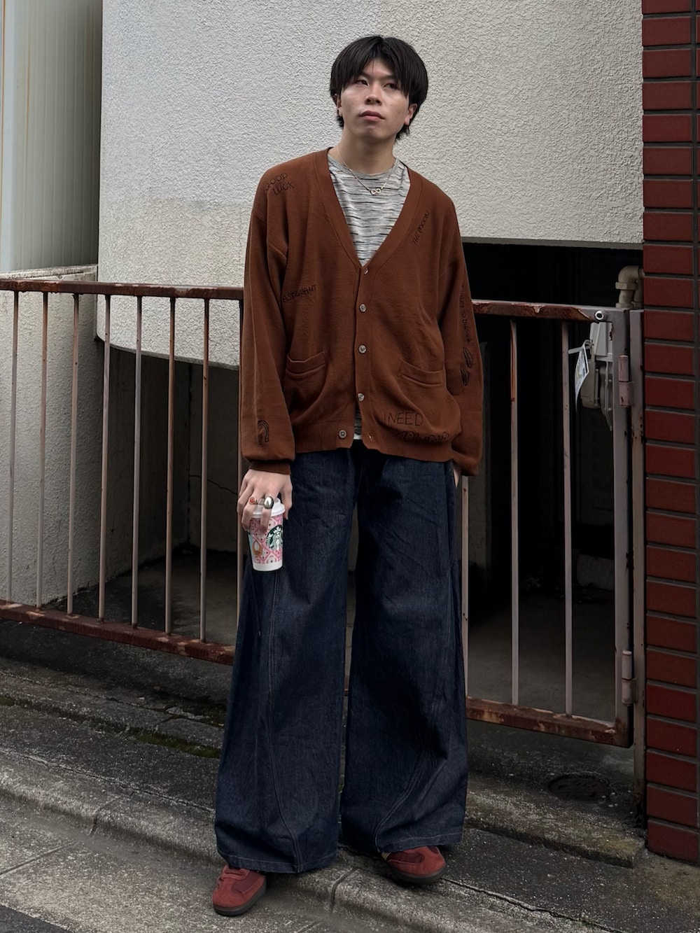 ブラウン系のカーディガン/ボレロ、グレー系のTシャツ/カットソー、ブルー系のデニムパンツを着用したメンズの春コーディネートの3枚目の写真