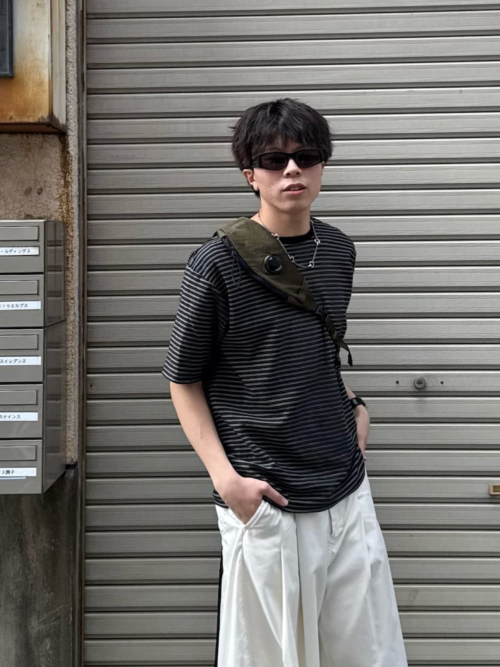ブラック系のTシャツ/カットソー、ホワイト系のその他パンツ、ブラック系のスニーカーを着用したメンズの夏コーディネートの3枚目の写真