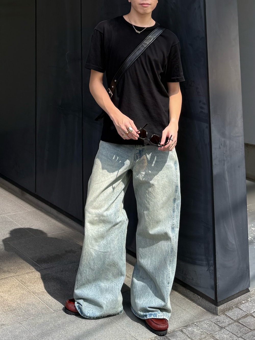 ブラック系のTシャツ/カットソー、ブルー系のデニムパンツ、ブラック系のショルダーバッグを着用したメンズの秋コーディネートの3枚目の写真