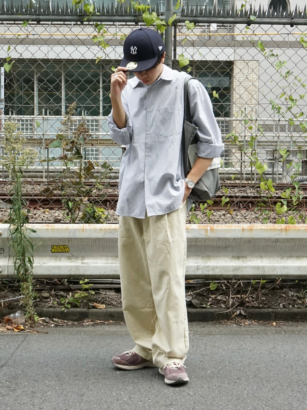ブラック系のシャツ/ブラウス、ベージュ系のチノパンツ、グレー系のトートバッグを着用したメンズの秋コーディネートの2枚目の写真