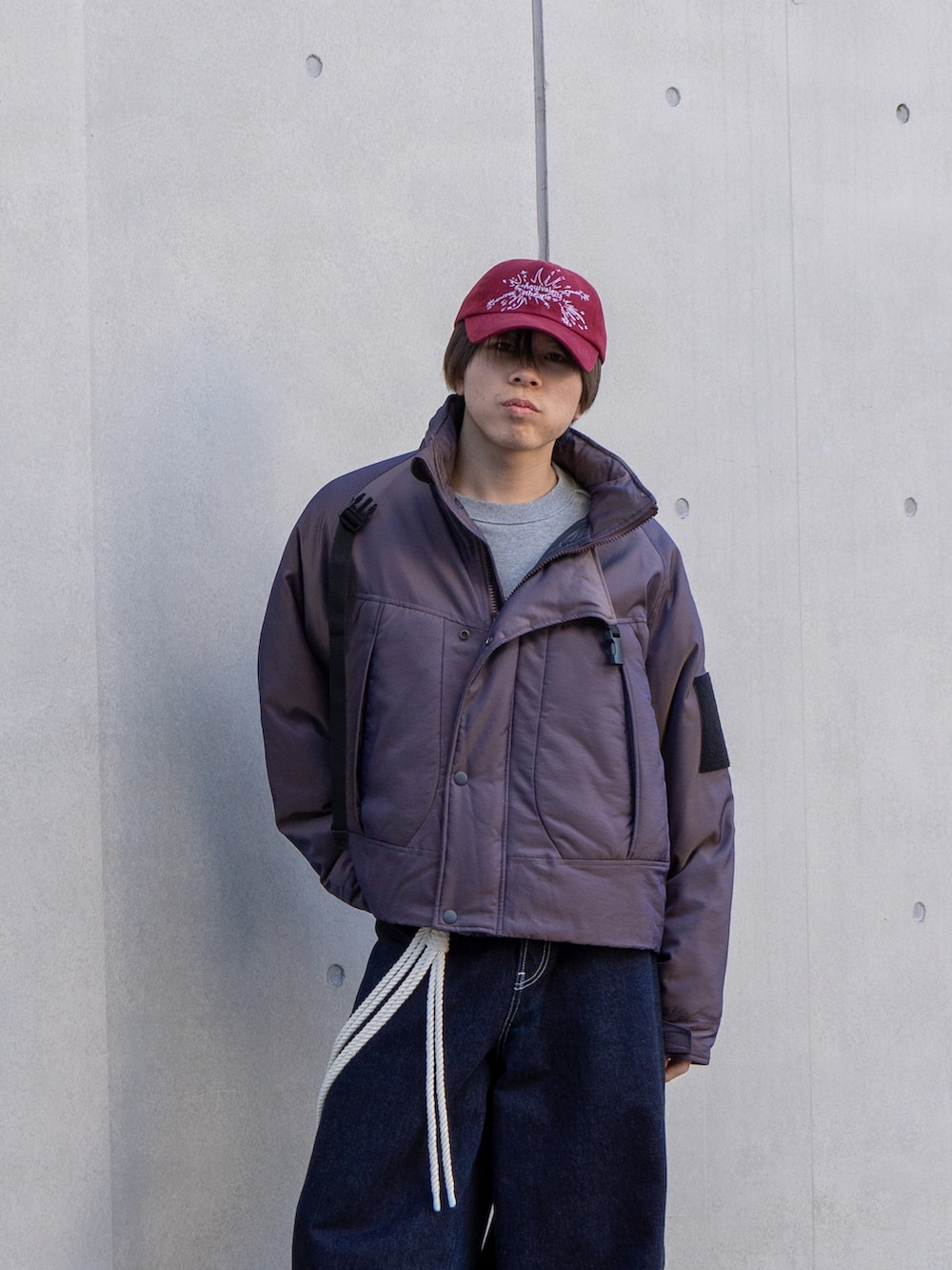 パープル系のブルゾン、グレー系のスウェット、ブラック系のスニーカーを着用したメンズの冬コーディネートの4枚目の写真