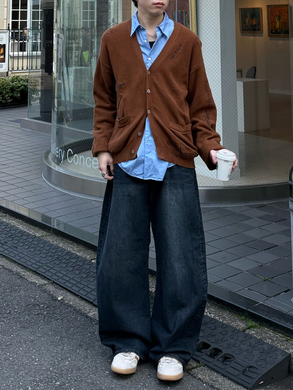 ブラウン系のカーディガン/ボレロ、ブルー系のデニムパンツ、ブルー系のスニーカーを着用したメンズの春コーディネートの4枚目の写真