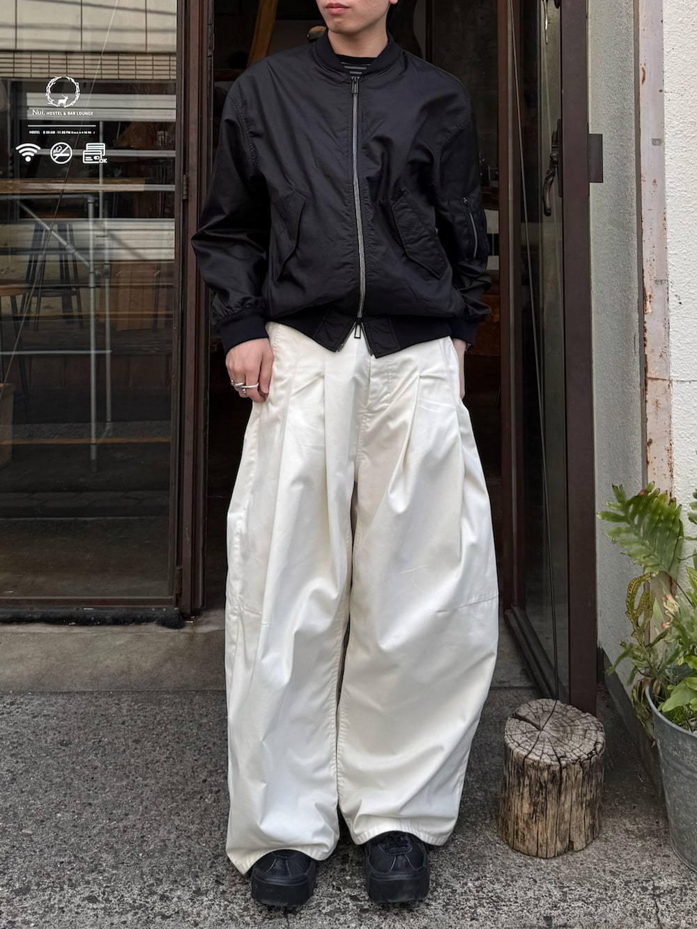 ブラック系のTシャツ/カットソー、ブラック系のブルゾン、ホワイト系のその他パンツを着用したメンズの春コーディネートの5枚目の写真