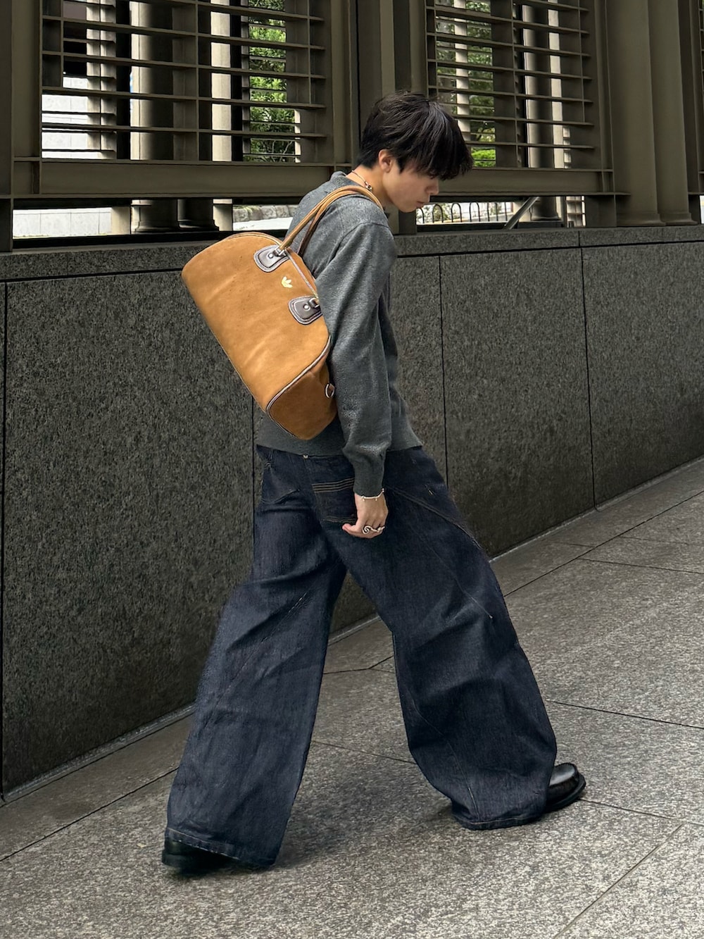 グレー系のシャツ/ブラウス、ブルー系のデニムパンツ、ベージュ系のバッグを着用したメンズの秋コーディネートの4枚目の写真