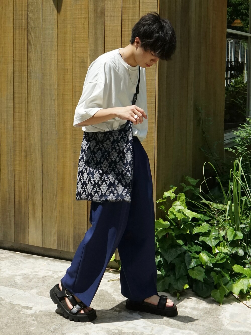 ホワイト系のTシャツ/カットソー、ブルー系のスラックス、ブルー系のショルダーバッグを着用したメンズの夏コーディネートの3枚目の写真