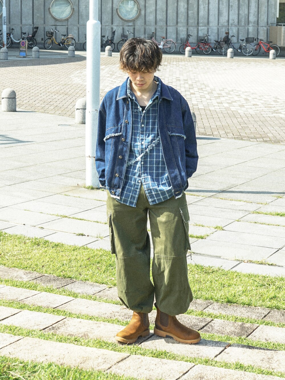 ブルー系のデニムジャケット、グリーン系のカーゴパンツ、ブラウン系のブーツを着用したメンズの秋コーディネートの3枚目の写真