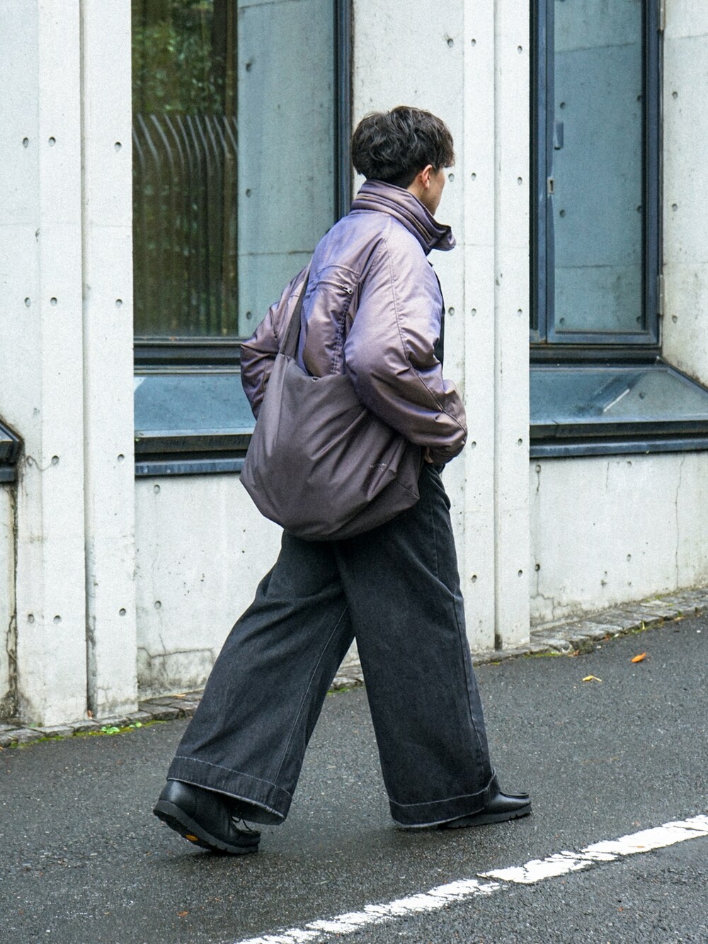 パープル系のブルゾン、ブラック系のデニムパンツ、グレー系のショルダーバッグを着用したメンズの冬コーディネートの2枚目の写真