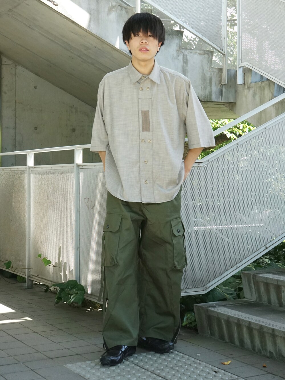 ベージュ系のシャツ/ブラウス、グリーン系のカーゴパンツ、ブラック系のローファーを着用したメンズの夏コーディネートの2枚目の写真