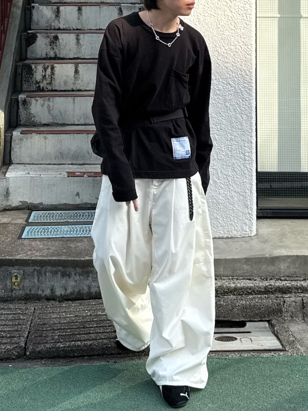 ブラック系のTシャツ/カットソー、ホワイト系のその他パンツ、ブラック系のボディバッグ/ウエストポーチを着用したメンズの春コーディネートの5枚目の写真